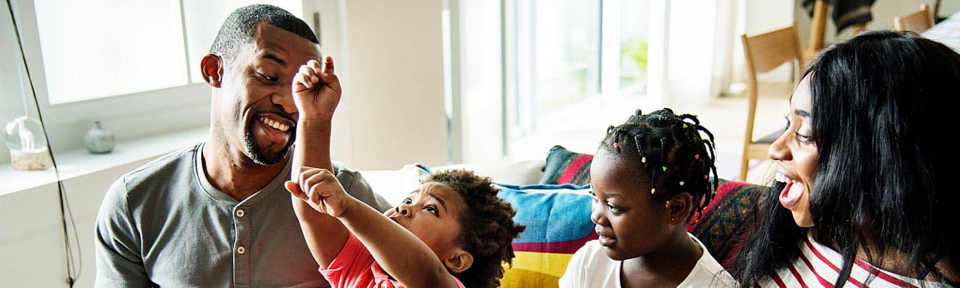 parents play with their kids on the couch and discuss what it means to buy term and invest the difference