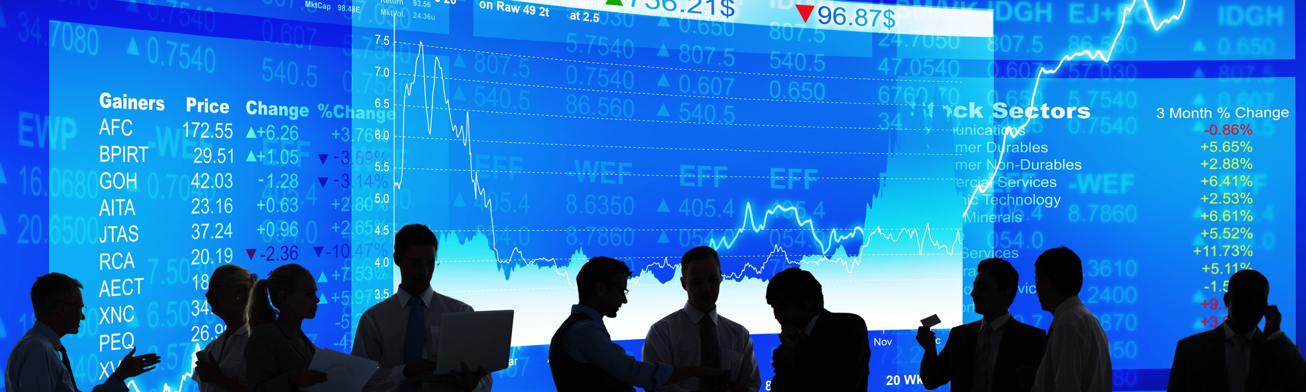 People in front of stock market screens