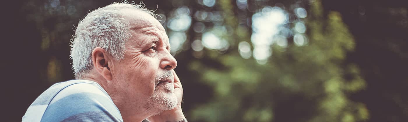 Portrait of senior man on the bridge, looking thoughtfully and thinking about declaring bankruptcy 
