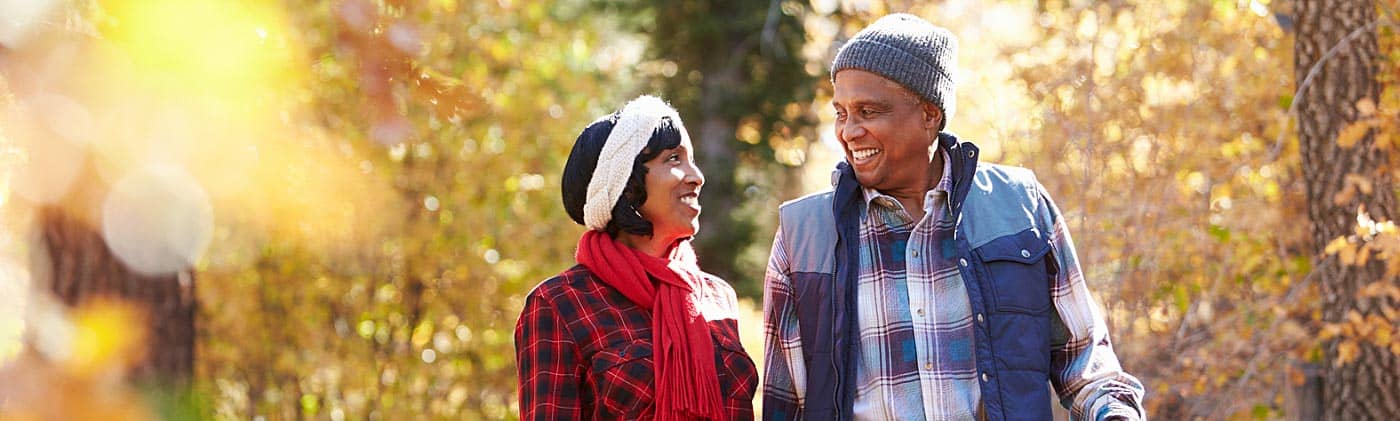 retired couple walking through the woods in the fall: immediate annuity