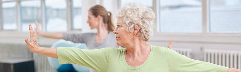 Retired woman teaching a yoga class after looking at cool retirement jobs