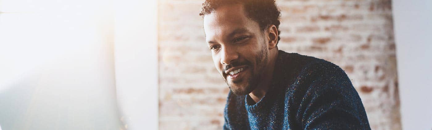 self-employed businessman works on his laptop in a sunny room to research: what is an IRA?