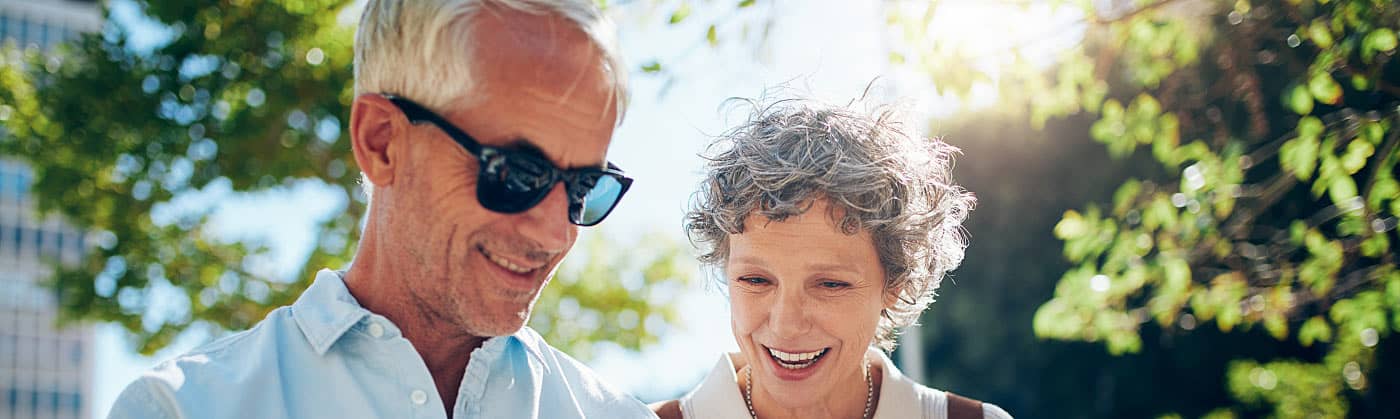 Senior couple checking map on a walk and talking about starting an emergency fund in retirement 