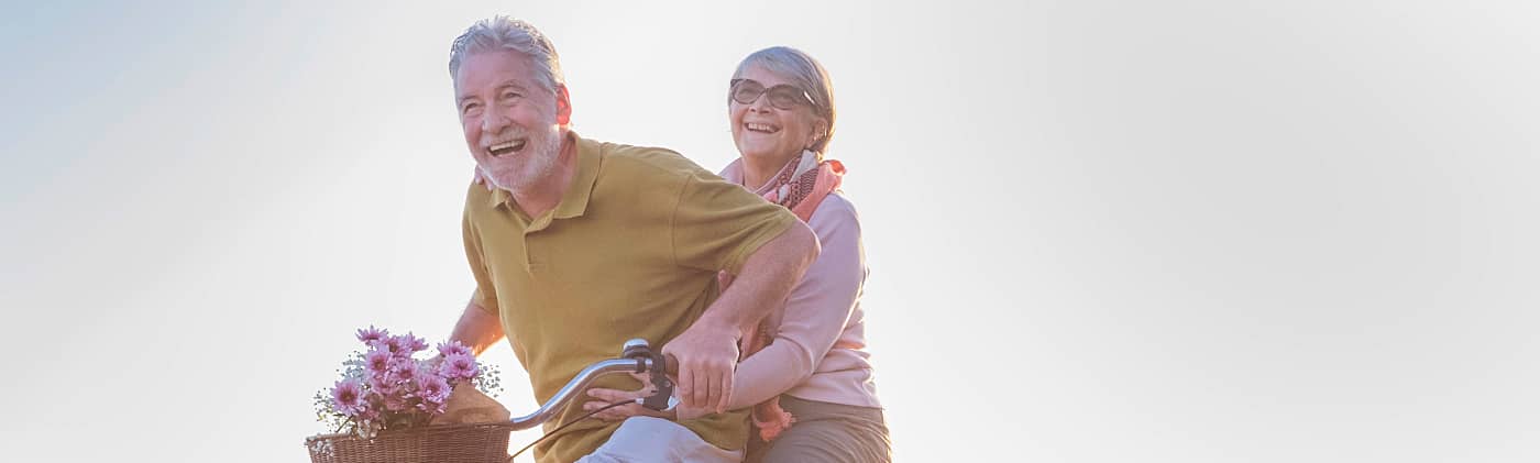 Senior couple riding a bike on a sunny day
