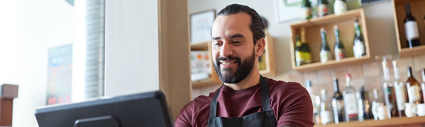 Small business owner standing at register after buying a small business