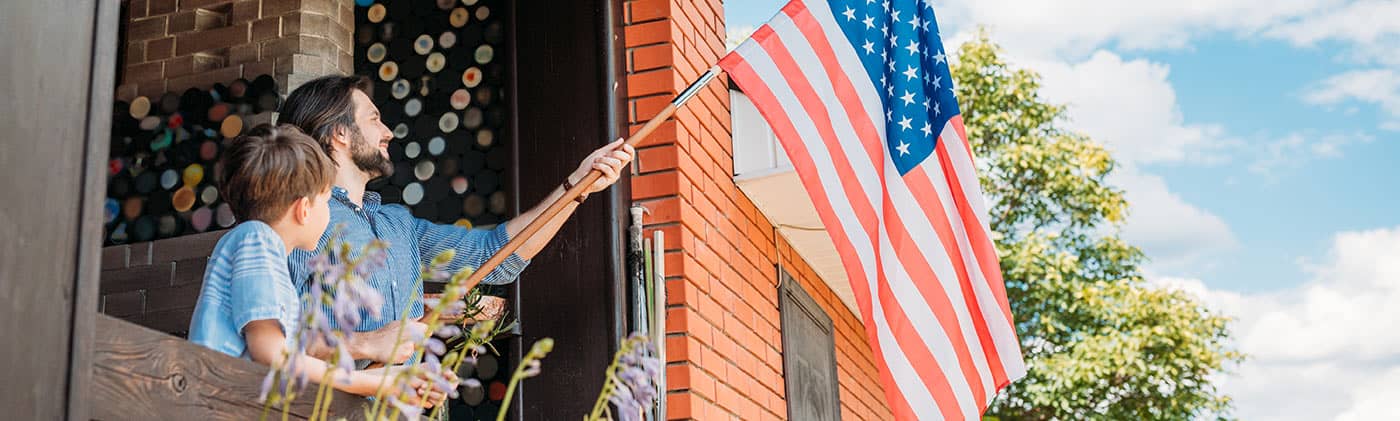 father hangs flag outside with his son and begins his life after the military by reviewing his finances