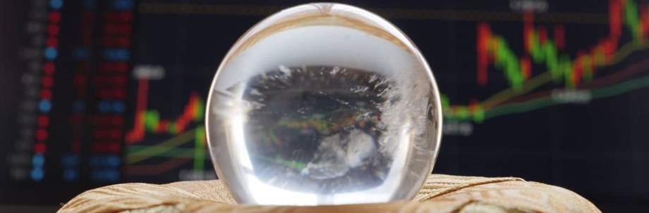 Economic forecast through a crystal ball. Future business forecast concept as a symbol for predicting the state of the economy as a crystal ball with a financial person looking forward.