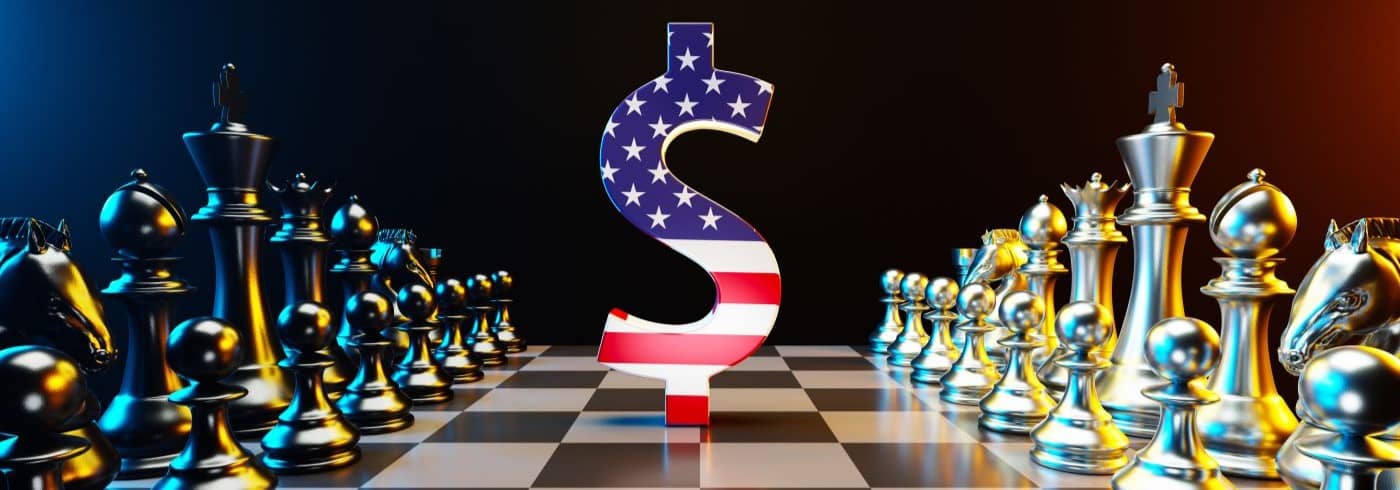 Single king chess piece textured with American flag and an American dollar sign are standing on black and white chessboard. 
