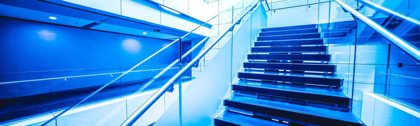 Low Angle View Of Stairs Leading Towards modern building. Detail of stone steps of stairway in blue tone
