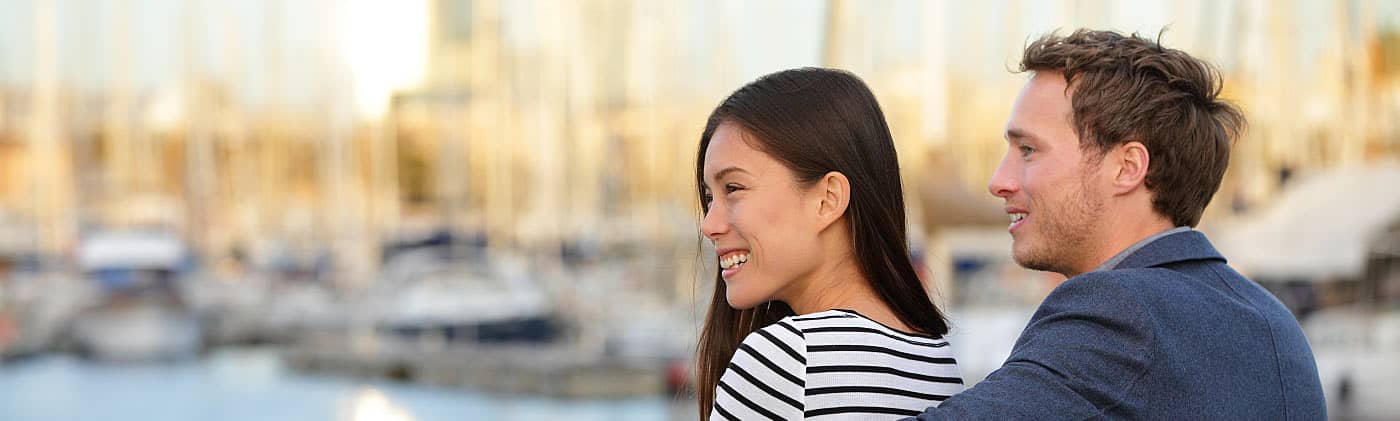 Young couple looking out at the harbor, symbolizing their insurance policy's free look period