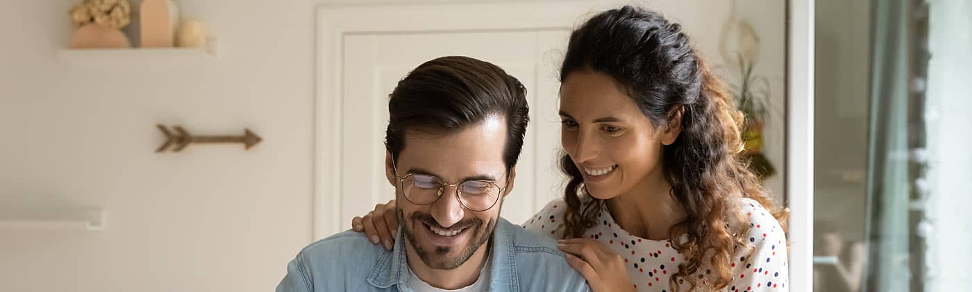 A young couple using a laptop, deciding when to get life insurance