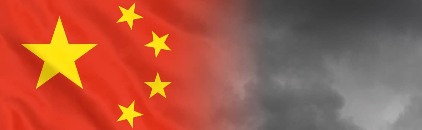 China economics financial crisis concept. Stock photo of China's flag in front of a dark cloud background.