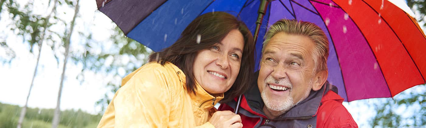 Woman standing in front of a tree and thinking about starting a rainy day fund