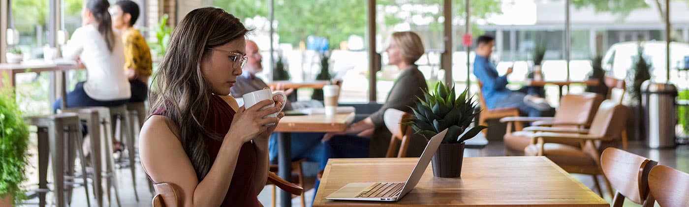 Woman freelancer working on laptop while sitting at the window in a coffee shop: irregular income