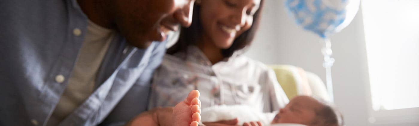 Young couple with their newborn son: budgeting for a baby