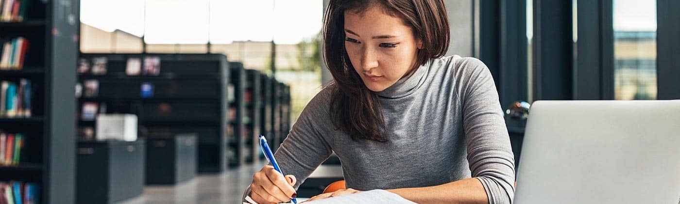 Young female student working in the library: student loans
