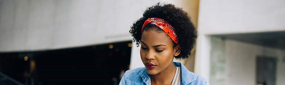 Younger African American woman researching ways to invest with little money