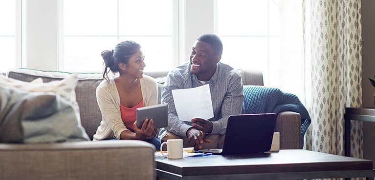 Couple at home planning finances on laptop