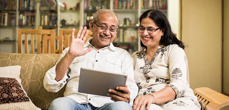 A happy couple sitting on a couch discusses what to do in retirement 