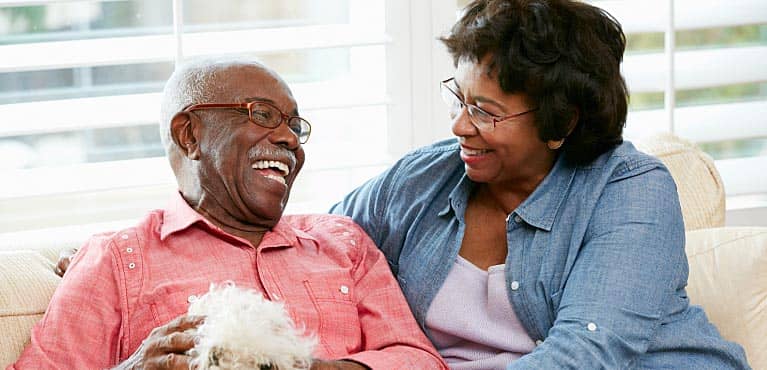 happy retired couple relaxes at home while talking and planning how to reduce their retirement taxes