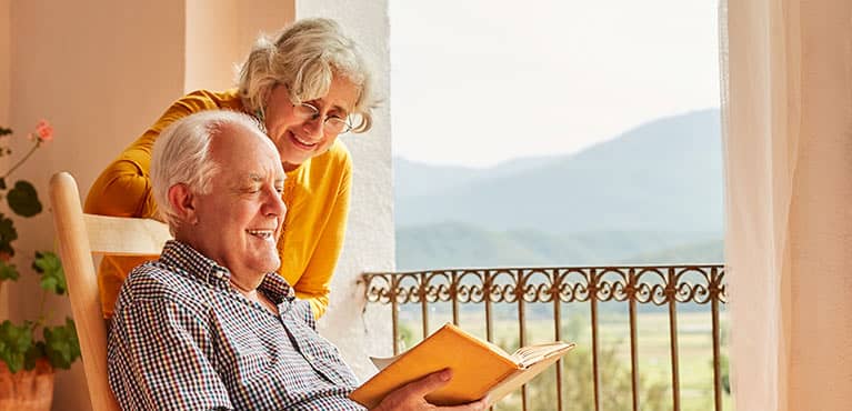 Elderly retired couple enjoying a good book on the porch
