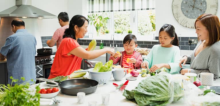 The entire family in the kitchen preparing a meal