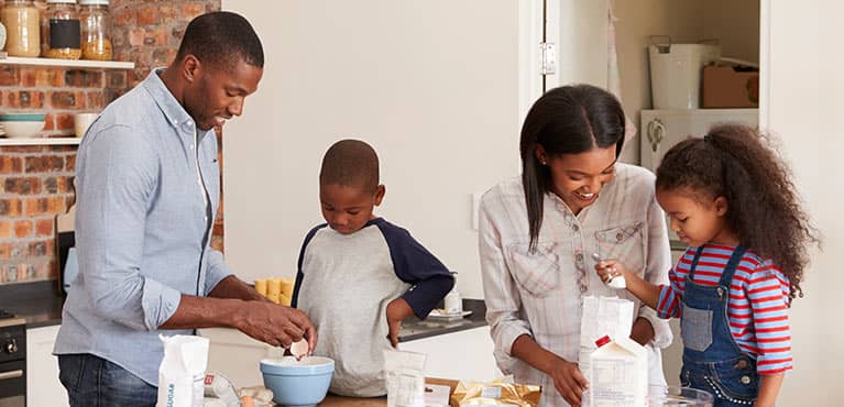Mom and dad with son and daughter baking in the kitchen