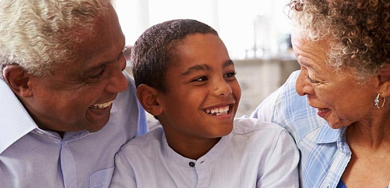 grandparents embrace their young grandson and granddaughter at home and think about inheritance