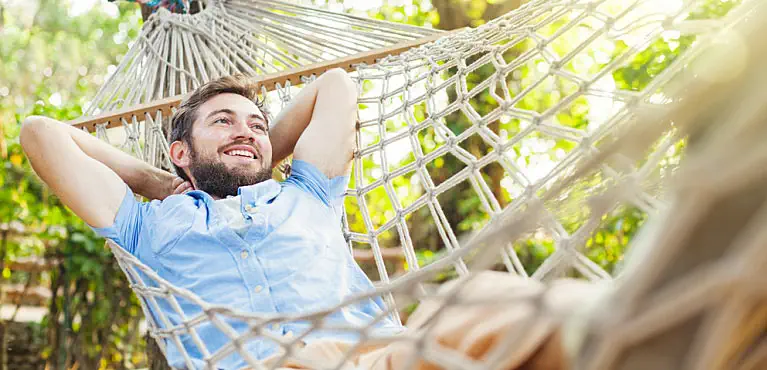 Young man in a hammock asks himself, "How much money do I need to retire at 40?"