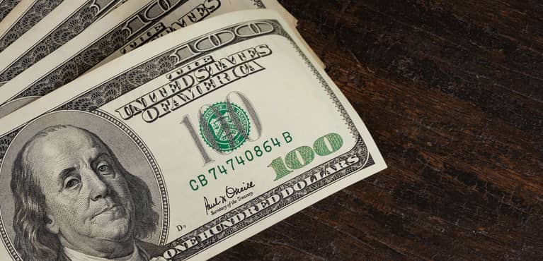 one hundred dollar bills on a table