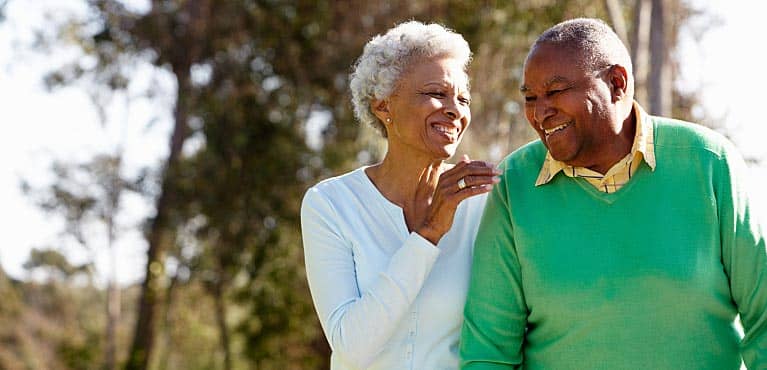 senior couple walks on a sunny day to discuss how annuities can provide guaranteed retirement income