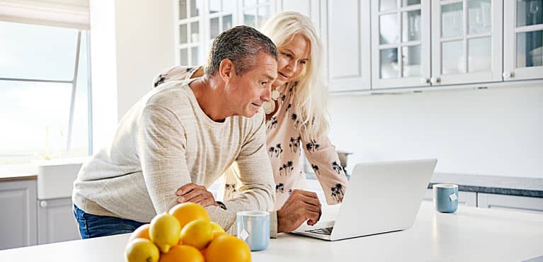 Senior couple meeting in kitchen on laptop discussing estate planning 101 