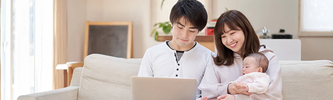 Asian couple with baby and laptop