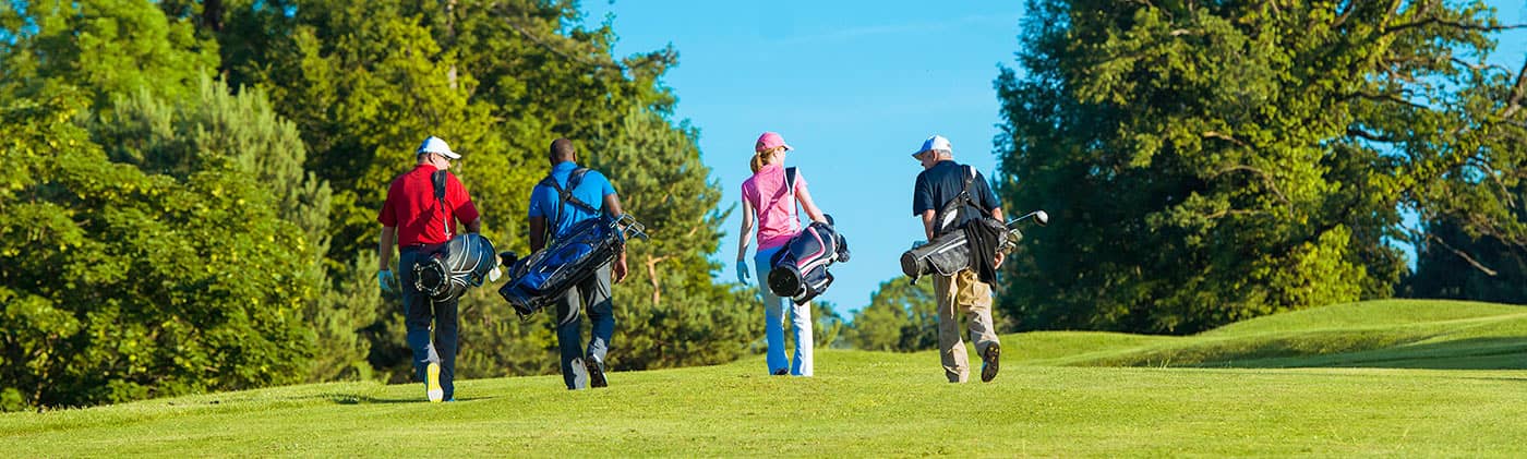 Golfers carrying bags