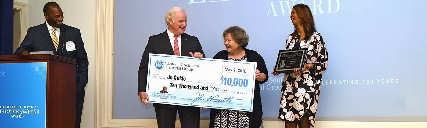 john barrett presenting a check to the winner of the hawkins educator of the year