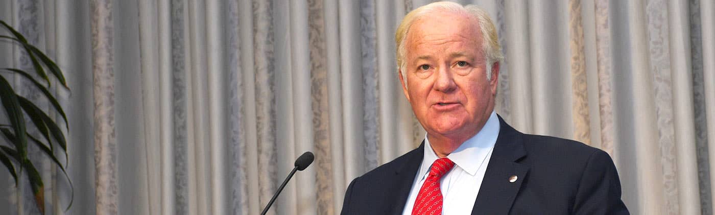 John Barrett at podium at EO event