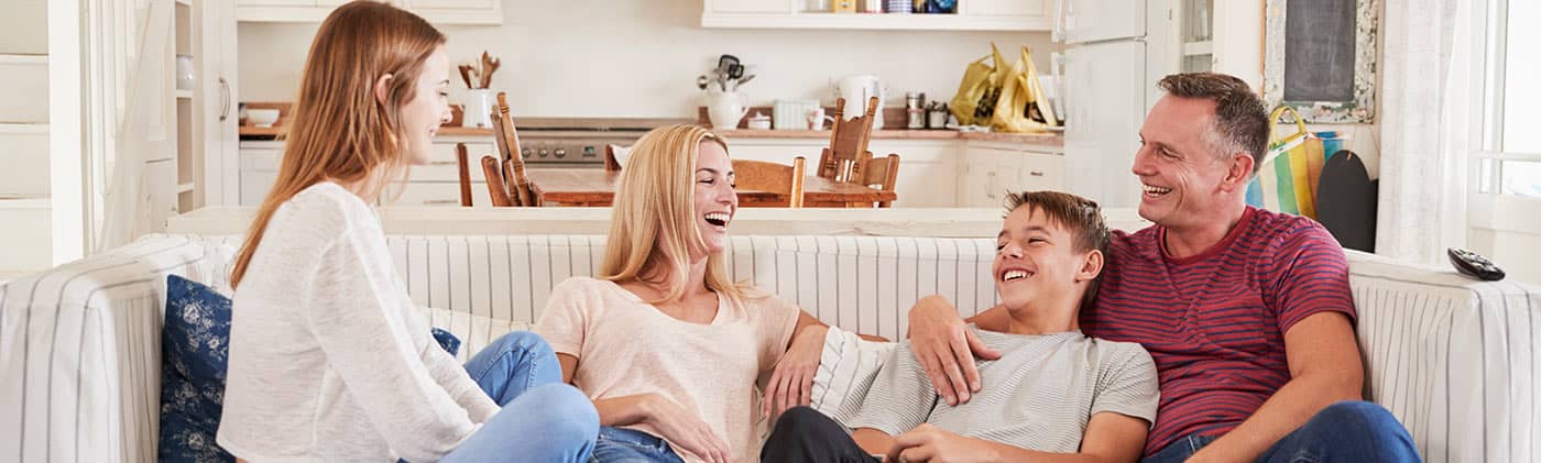 Parents with teenagers on couch