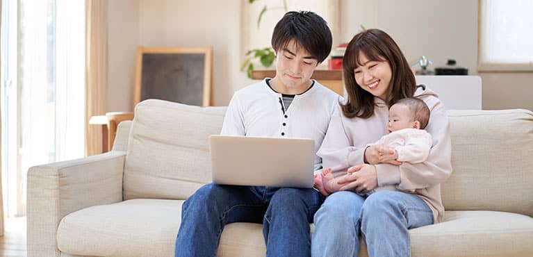 Asian couple with baby and laptop