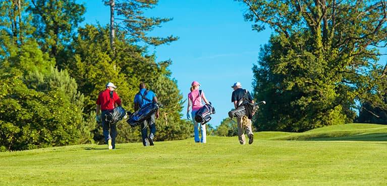 Golfers carrying bags