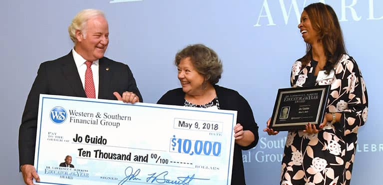 john barrett presenting a check to the winner of the hawkins educator of the year