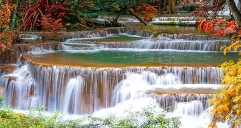 Cascading waterfalls surrounded by vibrant autumn colors.