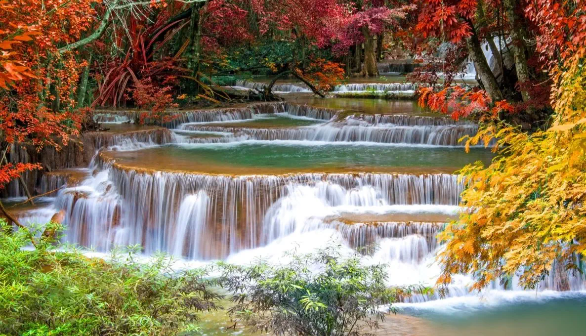 Cascading waterfalls surrounded by vibrant autumn colors.